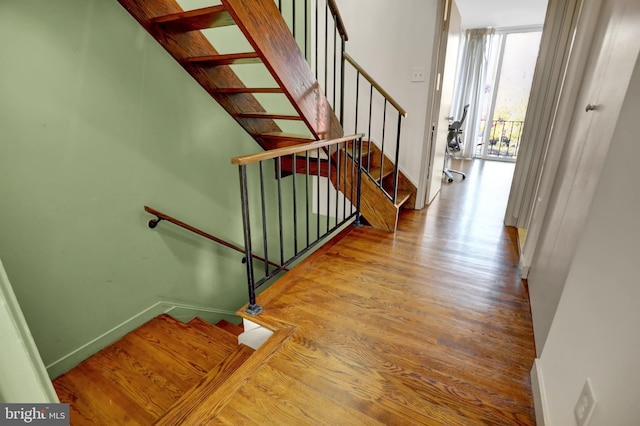 251 W Lafayette Ave, Baltimore, MD 21217 - staircase featuring wood finished floors, baseboards, and floor to ceiling windows