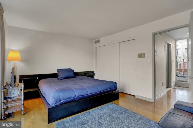 bedroom with multiple windows, a closet, and light wood-type flooring