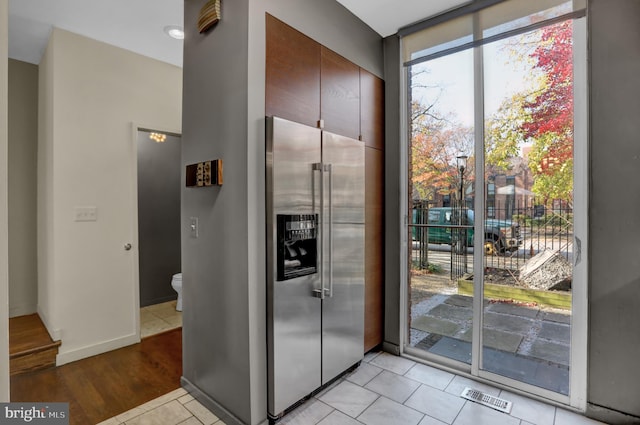 251 W Lafayette Ave, Baltimore, MD 21217 - doorway with light tile patterned floors, expansive windows, and baseboards