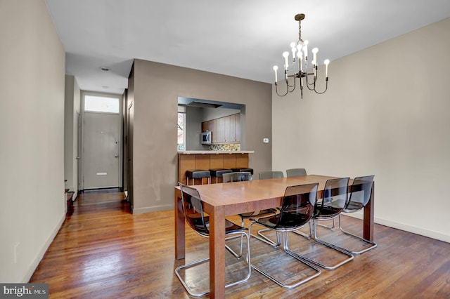 dining space featuring hardwood / wood-style floors and a notable chandelier