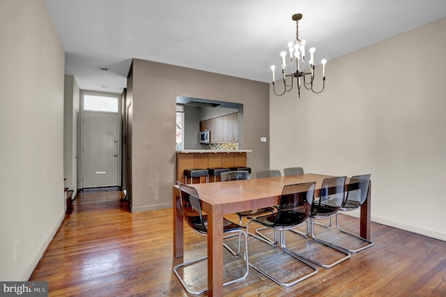 251 W Lafayette Ave, Baltimore, MD 21217 - dining area featuring a chandelier, wood finished floors, and baseboards