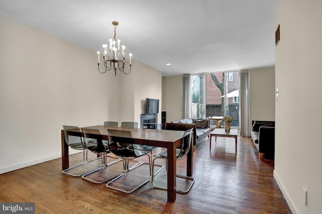 dining space featuring wood-type flooring and an inviting chandelier