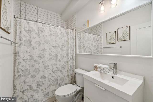 bathroom with walk in shower, vanity, and toilet