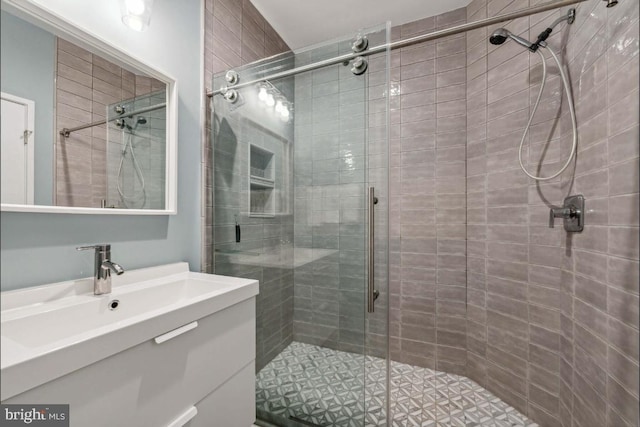 bathroom with a shower with door and vanity