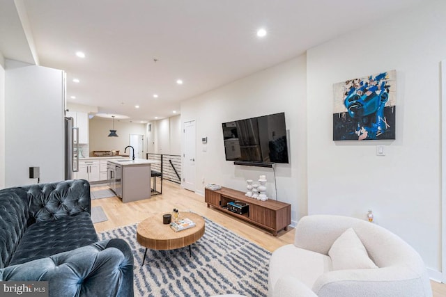 living room with sink and light hardwood / wood-style flooring