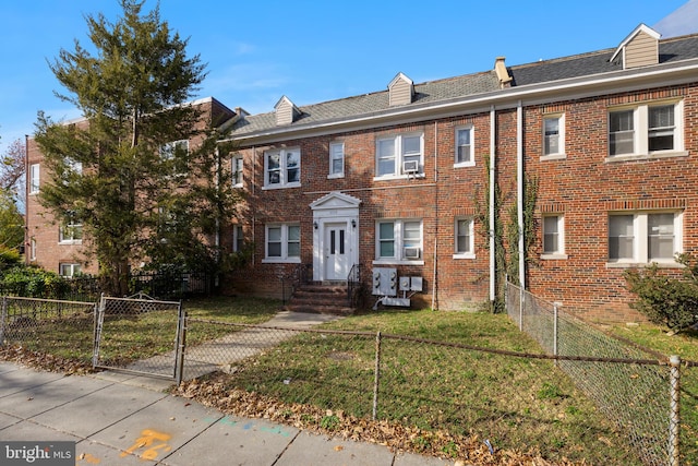 view of property with cooling unit and a front lawn