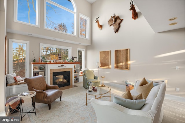 living room featuring a fireplace with flush hearth, a high ceiling, and carpet flooring