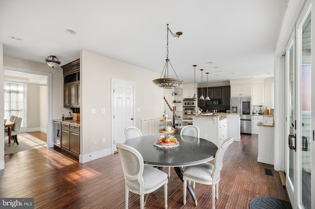 dining area featuring stairs, dark wood finished floors, visible vents, and baseboards