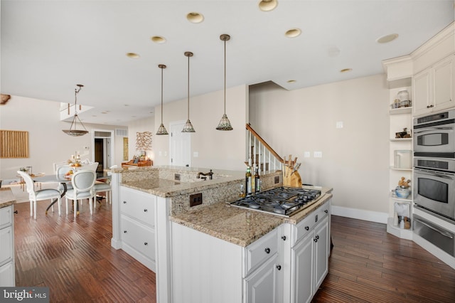 kitchen featuring stainless steel appliances, open shelves, dark wood finished floors, and a center island