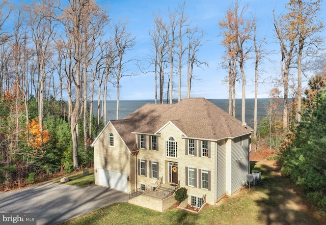 view of front of property featuring aphalt driveway, a shingled roof, and a garage