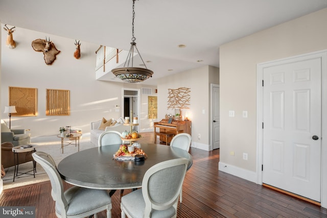 dining room featuring wood finished floors, visible vents, and baseboards