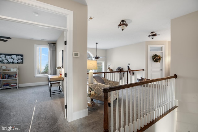 corridor featuring an upstairs landing, carpet flooring, visible vents, and baseboards