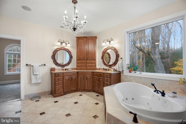 full bathroom with double vanity, baseboards, tile patterned floors, a whirlpool tub, and a sink