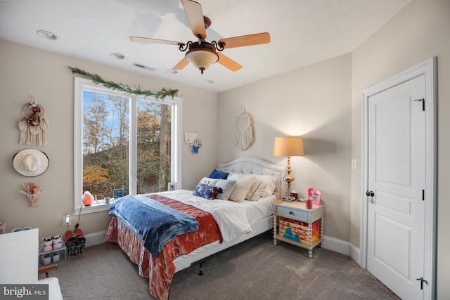 carpeted bedroom featuring baseboards, visible vents, and ceiling fan