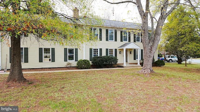 colonial-style house featuring a front yard