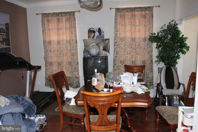 dining area with dark hardwood / wood-style flooring and crown molding