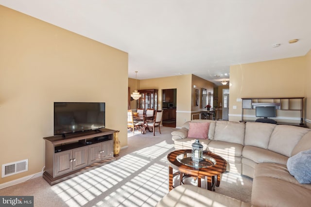 carpeted living room with a chandelier