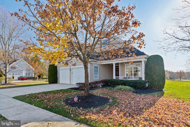 view of front facade with covered porch, a front yard, and a garage