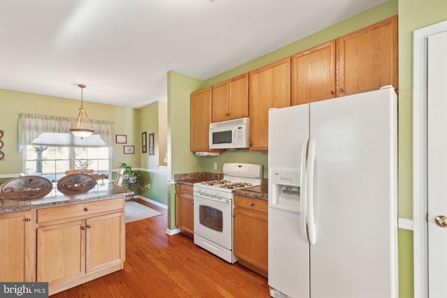 kitchen with pendant lighting, light wood-type flooring, and white appliances