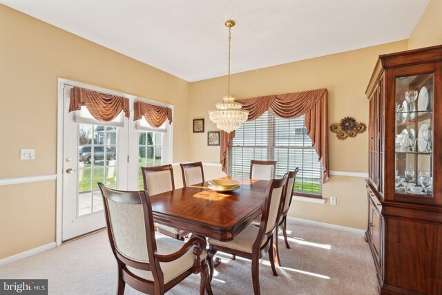 dining area featuring light carpet and an inviting chandelier