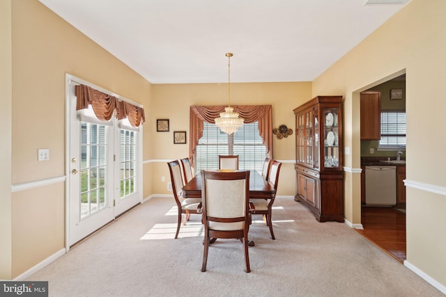 carpeted dining room featuring a chandelier