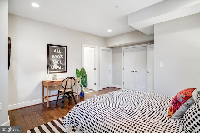 bedroom with a closet, recessed lighting, dark wood-style flooring, and baseboards