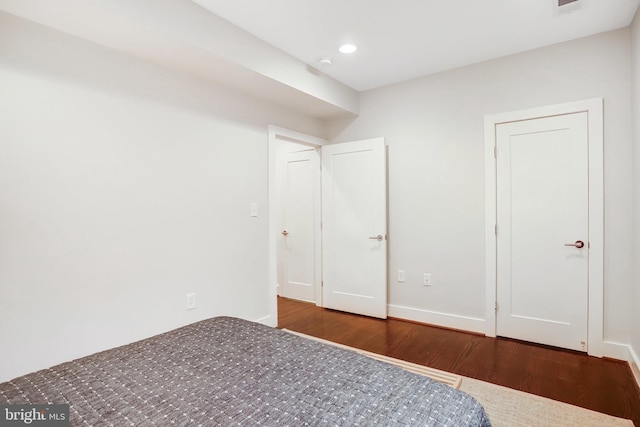 unfurnished bedroom with dark wood-style flooring, recessed lighting, and baseboards