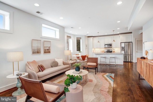 living room featuring baseboards, dark wood-type flooring, visible vents, and recessed lighting