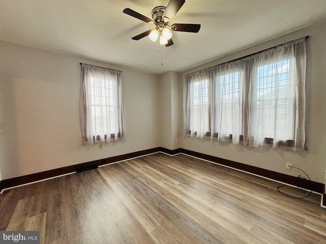 unfurnished room with wood-type flooring, a wealth of natural light, and ceiling fan