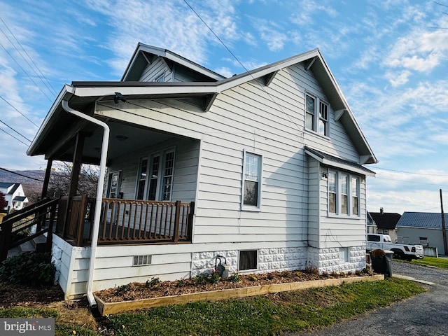 view of side of property featuring covered porch