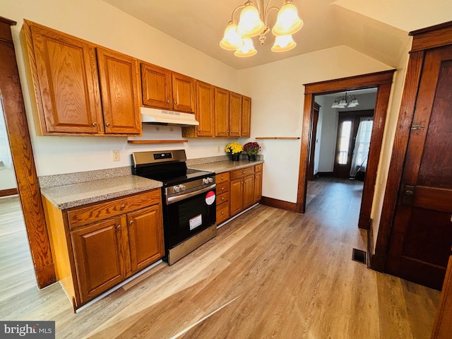 kitchen with french doors, hanging light fixtures, stainless steel range, light hardwood / wood-style floors, and a chandelier