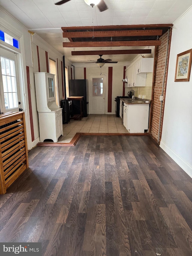 interior space with white cabinets, black fridge, range, and hardwood / wood-style flooring