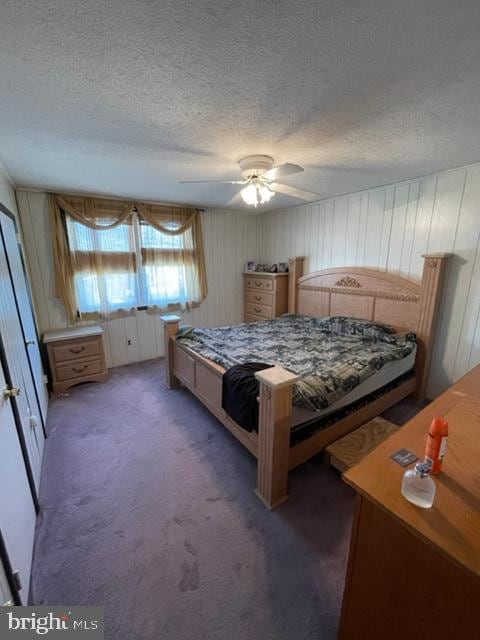 bedroom featuring dark colored carpet and a textured ceiling