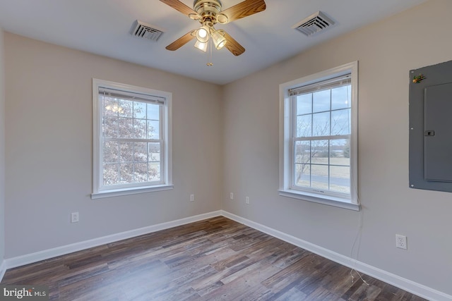 spare room with electric panel, dark hardwood / wood-style floors, and ceiling fan