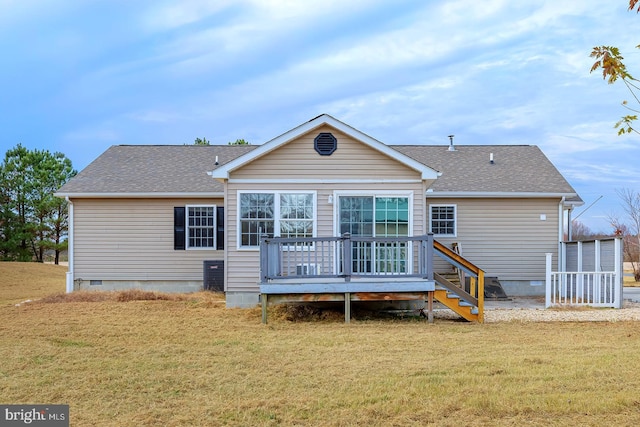 back of property with a wooden deck and a lawn