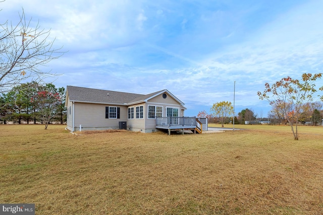 back of property featuring a lawn and a wooden deck