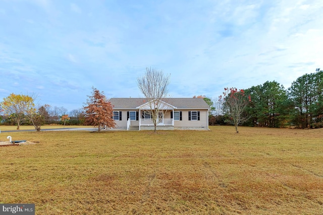 ranch-style house featuring covered porch and a front lawn