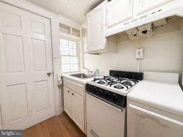 kitchen with wood-type flooring, white cabinetry, white range with gas cooktop, and sink