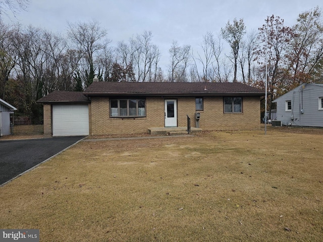 view of front of home featuring cooling unit, a front yard, and a garage