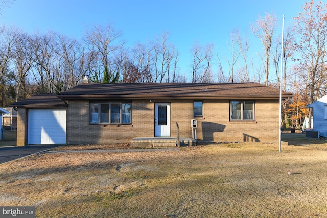 ranch-style house with central air condition unit, a front yard, and a garage