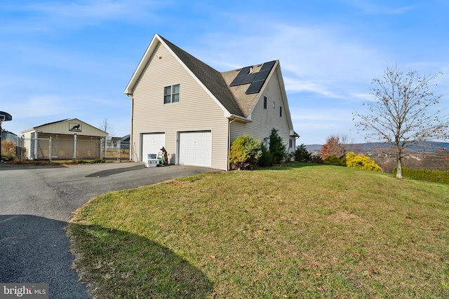 view of property exterior featuring a lawn, solar panels, and a garage