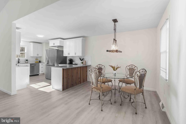 dining area with sink and light wood-type flooring