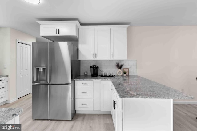 kitchen with kitchen peninsula, light wood-type flooring, tasteful backsplash, white cabinets, and stainless steel fridge with ice dispenser