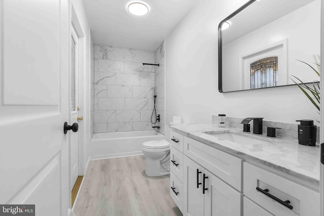 full bathroom featuring vanity, toilet, wood-type flooring, and tiled shower / bath