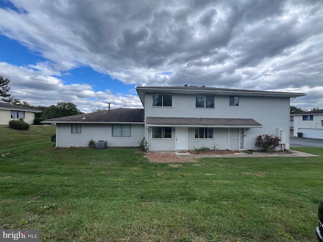 rear view of property with a yard and central AC