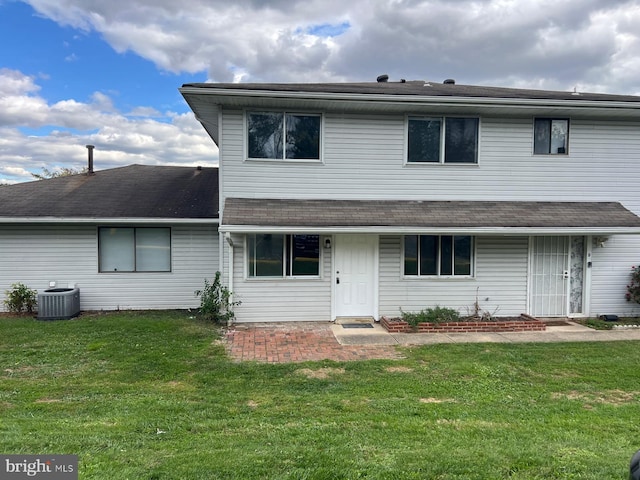 view of front property with central AC and a front yard