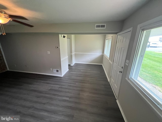 unfurnished room featuring ceiling fan, dark hardwood / wood-style flooring, and a healthy amount of sunlight