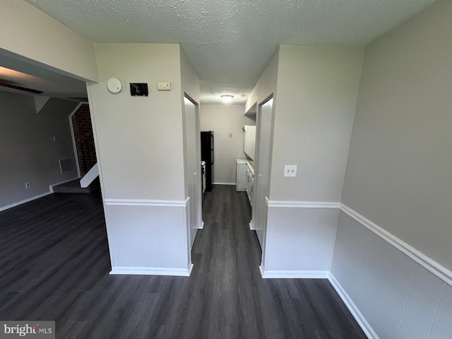 hall with dark hardwood / wood-style flooring and a textured ceiling