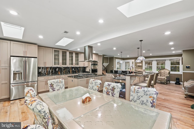 dining room with a skylight, light hardwood / wood-style flooring, and sink