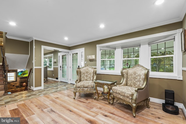 sitting room with light hardwood / wood-style floors and ornamental molding